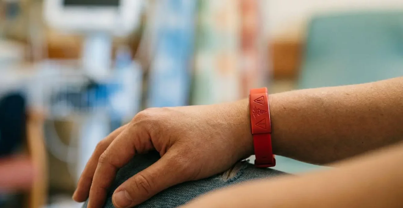 Bracelet d'identification médicale rouge avec symboles d'alerte sur poignet